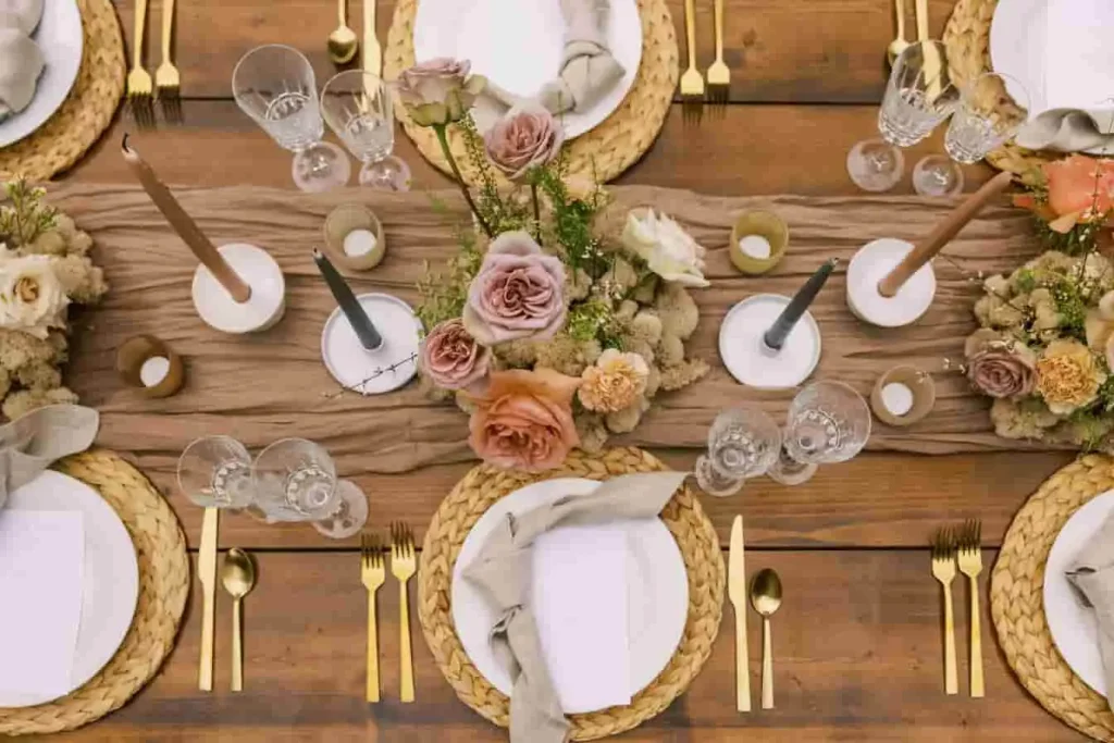 Déco table 30 ans avec bougies, fleurs et vaisselle dorée sur fond bois naturel et ambiance cosy.