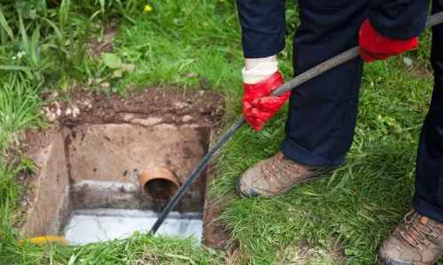 Technicien utilisant une aiguille de tirage pour le débouchage d'un fourreau télécom