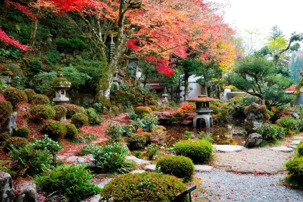 Paysage japonais avec étang et sculptures traditionnelles, visuel représentant l’aménagement d’un jardin propice à la contemplation et à la sérénité