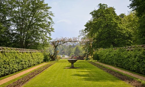 Jardin structuré avec allée centrale et haies taillées évoquant esthétique formelle et contraste avec principe de planter une haie libre plus naturelle