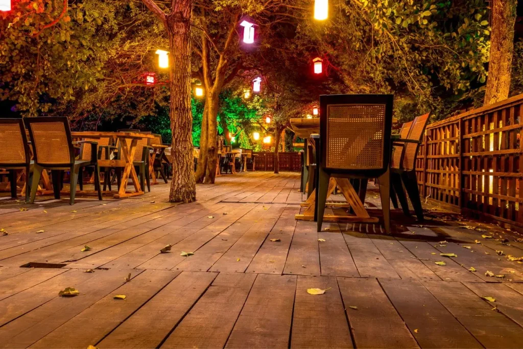 Terrasse en bois composite installée sous lanternes colorées, image qui illustre un projet réalisé soi-même pour créer un espace chaleureux.