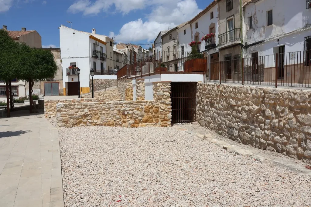Cour pavée entourée de murs en pierre, image illustrant un aménagement extérieur où un mur en gabion pourrait renforcer la structure.