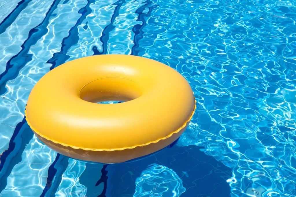 Bouée jaune flottant sur eau bleue scintillante, image qui illustre l’importance d’hiverner correctement une piscine hors-sol pour la préserver.