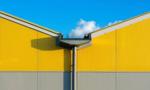 Vue d’un bâtiment moderne avec gouttière métallique, reflet de l’importance de l’entretien des gouttières de toiture pour éviter infiltrations.