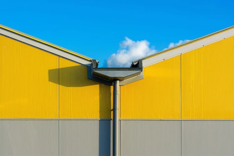 Vue d’un bâtiment moderne avec gouttière métallique, reflet de l’importance de l’entretien des gouttières de toiture pour éviter infiltrations.