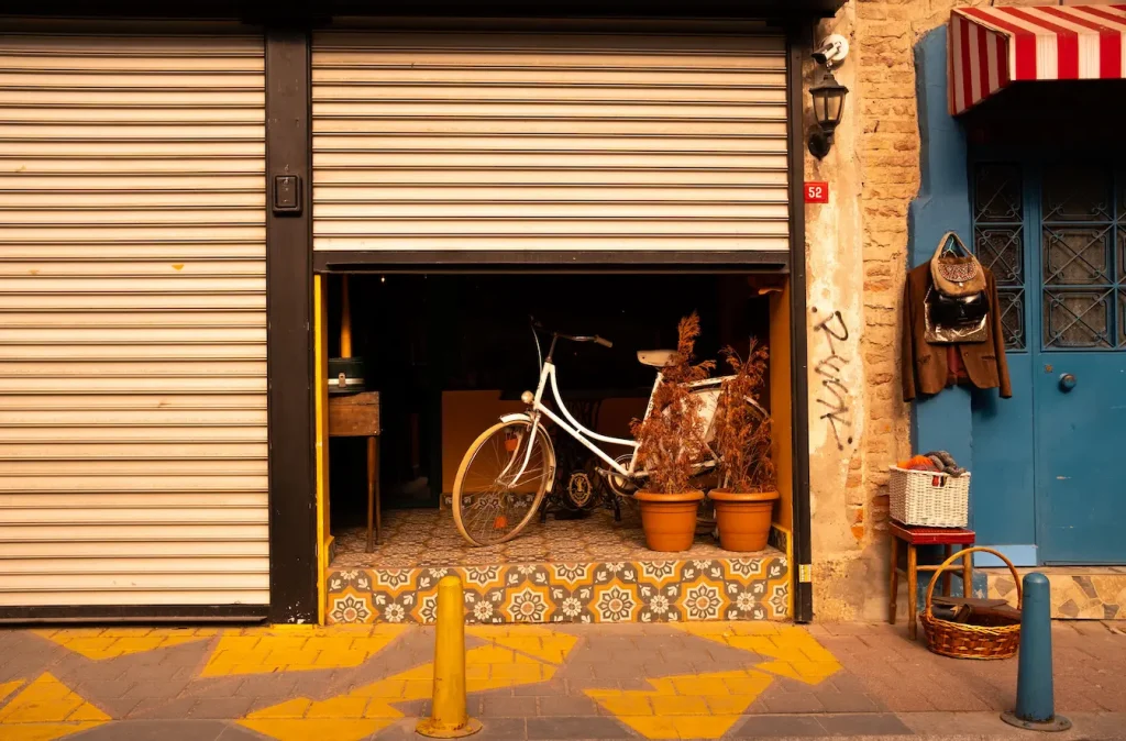 Store en métal relevé laissant apparaître un vélo, reflet de l’entretien d’un volet roulant électrique et de la durabilité du système.