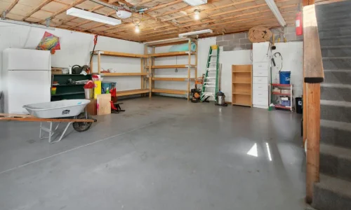 Garage organisé avec étagères et outils, symbole des espaces transformables en buanderie pratique.