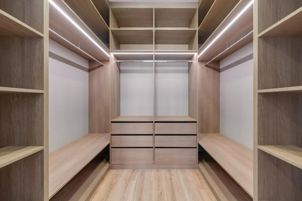 Dressing moderne en bois clair avec étagères ouvertes et tiroirs, symbole des projets d