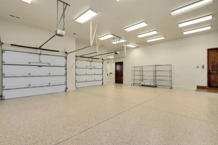 Garage spacieux et lumineux avec sol époxy et étagères métalliques, symbole des possibilités d’aménagement en dressing pratique.