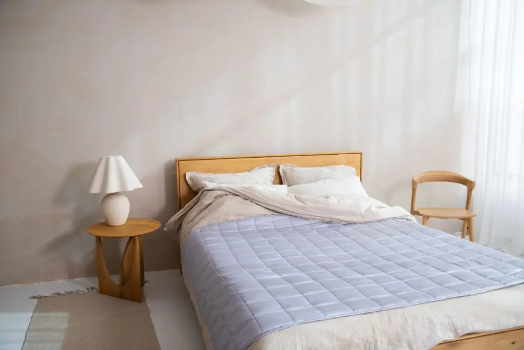 Une chambre lumineuse et minimaliste avec un lit douillet aux tons doux, idéale pour comparer la différence entre matelas mémoire de forme et ressorts.